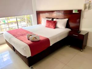 Un dormitorio con una cama grande con dos cajas. en Hotel Dorado Gold, en Bogotá