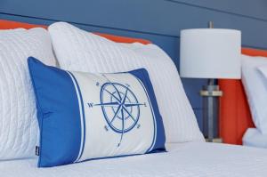un letto con un cuscino con un cartello di pace sopra di Flagship Inn a Boothbay Harbor