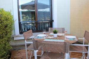 a table with chairs and wine glasses on a balcony at Lilia Apartments Каваци, Созопол in Sozopol