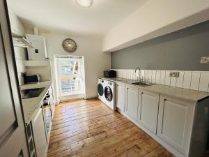 una cocina con fregadero y lavadora en Dolgellau Grand Heights Apt, en Dolgellau 24 fotos más