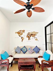 a living room with a couch and a ceiling fan at 2BR Pool Villa&Garden - Bali style by La Perla Phuket Rawai in Ban Saiyuan (1) +17 photos