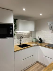 a white kitchen with a sink and a microwave at LAR DE SEFA in Redondela