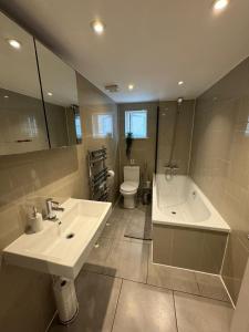 Brentford Guest Rooms في برينتفورد: حمام مع حوض وحوض استحمام ومرحاض