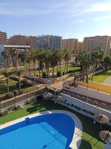 a view of a swimming pool with palm trees and buildings at Apartamento en Magic World. Nueva Marina Dor in Oropesa del Mar