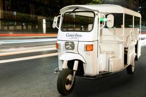 un pequeño carrito de golf blanco conduciendo por la calle en Centre Point Chidlom en Bangkok