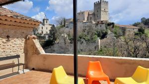 een balkon met stoelen en een kasteel op de achtergrond bij La maison de Daniel - Esparron-de-Verdon in Esparron-de-Verdon