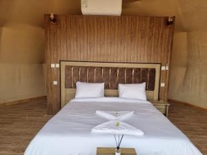 ein Schlafzimmer mit einem Bett mit einem weißen Handtuch darauf in der Unterkunft WADl RUM DESERT CAMP in Wadi Rum