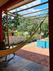 a hammock on a patio with a pool at Casita Amarilla in the Yellow City in Izamal
