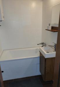 een badkamer met een wastafel en een bad bij Apartament Aleksander in Ciechocinek
