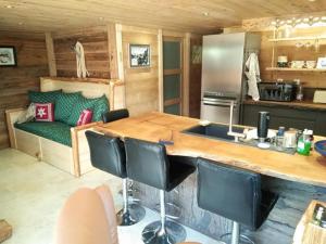 a kitchen with a large wooden table in a room at Le refuge du poète in Saint-François-de-Sales