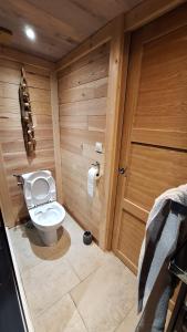 a bathroom with a toilet in a wooden room at Le refuge du poète in Saint-François-de-Sales