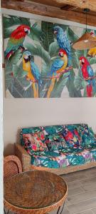 a couch with a painting of colorful birds on it at La petite tanière in Fontan