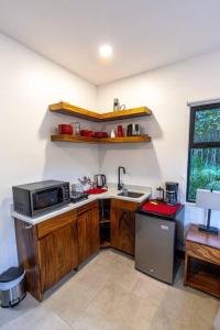 a small kitchen with a sink and a microwave at Grande Espiritu 2 bedroom Casita, close to beach, 2 queen beds in Refundores