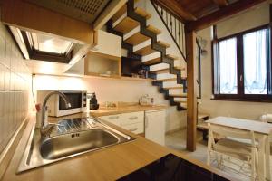 una cucina con lavandino e una scala a chiocciola di Casetta Ines, your stay in the city center a Viterbo