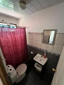 a bathroom with a toilet and a sink at La Casa de Mamá Coyita in Cartago