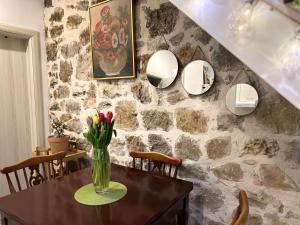 eine Vase mit Blumen auf einem Tisch in einem Zimmer in der Unterkunft Etno village Mihailovic II in Herceg-Novi