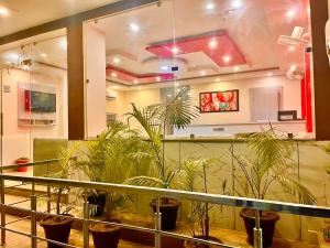 una hall con piante in vaso in una stanza di Hotel The Pacific Paradise a Haridwār