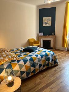 1 dormitorio con cama, mesa y chimenea en Chez Delphine, en Bourg-en-Bresse