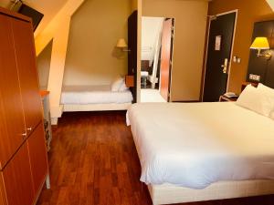 a hotel room with two beds and a hallway at Logis Hôtel La Brèche de Roland in Gèdre