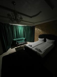 a bedroom with a bed and a green curtain at pensiunea medellin in Tulcea