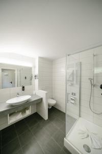 ein Bad mit einem Waschbecken, einem WC und einer Dusche in der Unterkunft Hotel Kühbergalp in Gunzesried