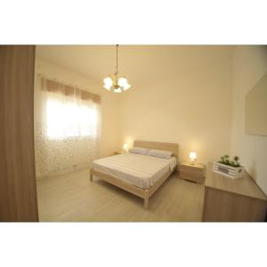1 dormitorio con 1 cama, ventana y 2 luces en Villetta Rosa House 100 meters from the blue sea, en San Pietro in Bevagna