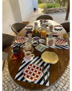 a wooden table with plates of food on it at Vila ALEGRIA CH2 in Estói