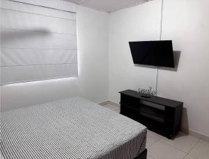 1 dormitorio con 1 cama y TV de pantalla plana en Great Location, Apartment Close to the Malecón en Barranquilla