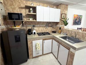 eine Küche mit einem schwarzen Kühlschrank und einer Spüle in der Unterkunft Great Location, Apartment Close to the Malecón in Barranquilla