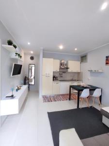a kitchen and living room with a table and chairs at La casa dei gelsomini in Alassio