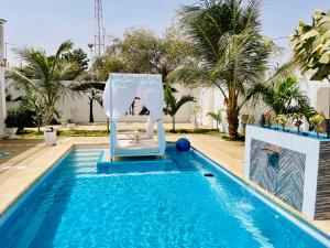 un arco blanco en una piscina con piscina en KEUR MATY Charmante et Moderne Villa 5 chambres, 5 salles de bains à Warang en Ouoran