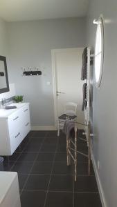 La salle de bains est pourvue de carrelage noir et d'un lavabo blanc. dans l'établissement Chb double avec baignoire, au Mans