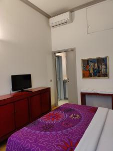 a bedroom with a purple bed and a flat screen tv at Brera Vicolo Fiori in Milan