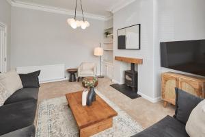 a living room with a couch and a tv at Roslyn House in Pateley Bridge