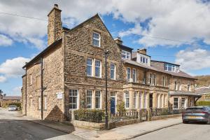 an old brick building on the side of a street at Roslyn House in Pateley Bridge