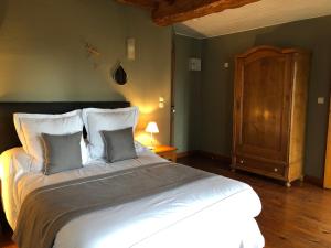 a bedroom with a large white bed with two pillows at le chateau de PENIN in Penin