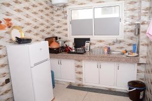 La cuisine est équipée d'un réfrigérateur blanc et d'un évier. dans l'établissement logmois, à Rabat