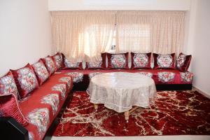 a living room with a red couch and a table at logmois in Rabat