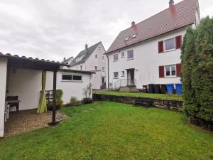 a yard with two white houses and a fence at 3 Zimmer Ferienwohnung mit eigenem Garten Trossingen in Trossingen