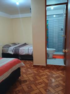ein Schlafzimmer mit 2 Betten und ein Badezimmer mit einem WC in der Unterkunft Hotel Everest in Pisac