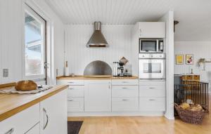 Una cocina con gabinetes blancos y un fregadero. en Cozy Home In Glesborg With Kitchen, en Glesborg