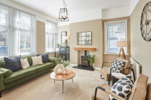 a living room with a green couch and a table at Roslyn House in Pateley Bridge