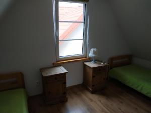 a small room with two beds and a window at Domek nad jeziorem Mazury Kobyłocha 13a in Szczytno