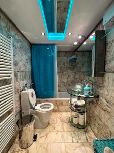 ein Bad mit WC und blauem Licht in der Unterkunft South Coast Voula Beach Sea RIVIERA Suite in Athen