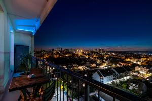 een balkon met uitzicht op de stad 's nachts bij Sunset Appart-Hotel 3 chambres, 2 Salles de Bain, proche Paris, Massy & Orly in Longjumeau