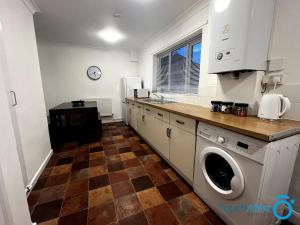 a kitchen with a washer and dryer in it at Large Cosy Home - B'ham, Solihull, NEC, M42, HS2 in Birmingham
