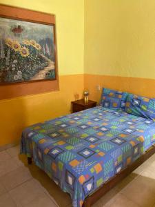 a bedroom with a bed with a painting on the wall at Hotel Las Salinas in Zihuatanejo +59 photos