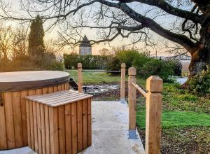 Idéal pour 2 - Moulin avec bain nordique et vue panoramique في Galapian: مقعد خشبي بجانب سور خشبي