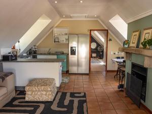 a kitchen with a refrigerator and a living room at Serenity Lodge in Clarens