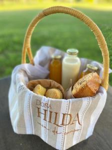 una cesta de comida con una botella de leche y pan en Doña Hilda en Mercedes